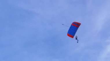 Paraşütçü Mavi Gök 'te Paraglider Üzerinde Uçuyor ve Yeşil Çimen' e İniyor. 4K.