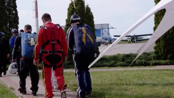 El equipo de paracaidistas está caminando por aeródromo a avión antes del despegue en el aeropuerto — Vídeo de stock