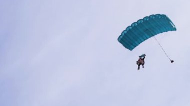 Paraşütçüler Mavi Gök 'te Paraglider' la Uçuyor ve Yeşil Çimen 'e İniyor. 4K