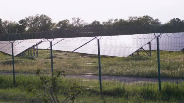 Painéis solares cercados com cerca de arame farpado. Pilhas solares. 4K — Vídeo de Stock