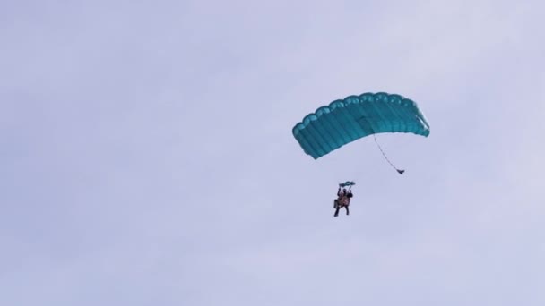 在蓝天的滑翔机上和在绿草上的土地上的抛物面苍蝇。4K. — 图库视频影像