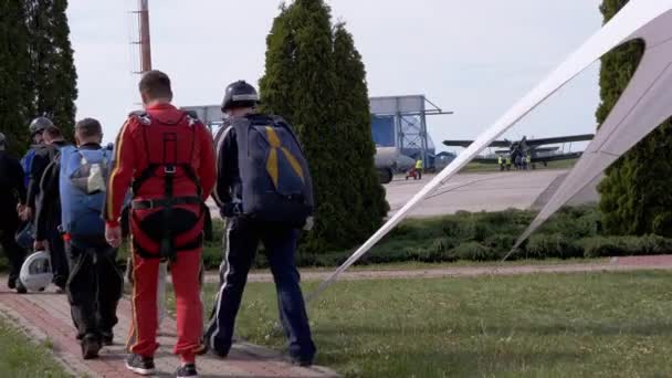 Csapat ejtőernyősök sétál repülőtéren a repülőgép felszállás előtt a repülőtéren — Stock videók