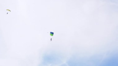 Paraşütçüler Bulutlu Mavi Gökyüzü 'nün Arkaplanına Karşı Bir Paraglider Üzerinde Uçuyor. 4K