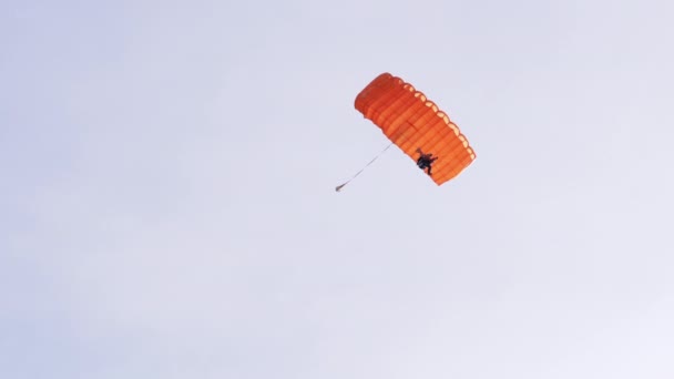 Los paracaidistas vuelan en un parapente contra el fondo del cielo azul con nubes. 4K — Vídeo de stock