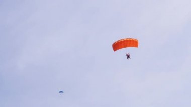 Paraşütçüler Mavi Gök 'te Paraglider' la Uçuyor ve Yeşil Çimen 'e İniyor. 4K