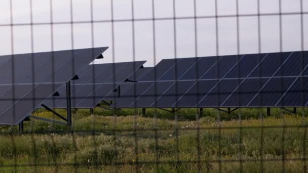 Paneles solares vallados con valla de alambre de púas. Baterías solares. 4K — Vídeos de Stock