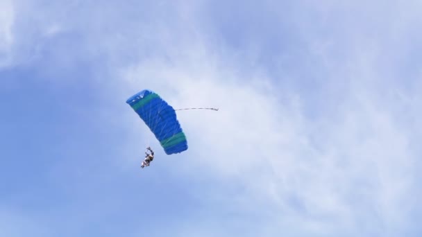 Los paracaidistas vuelan en un parapente contra el fondo del cielo azul con nubes. 4K — Vídeo de stock