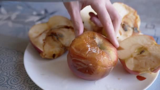 La mano femenina corta una manzana podrida en un plato con un cuchillo. Frutas malcriadas y mohosas — Vídeos de Stock