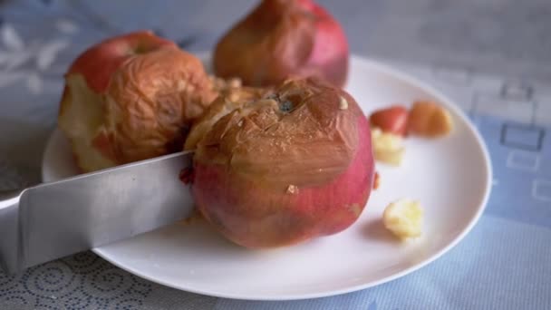 Mano femminile taglia una mela marcia su un piatto con un coltello. Rovinato, Frutta ammuffita — Video Stock