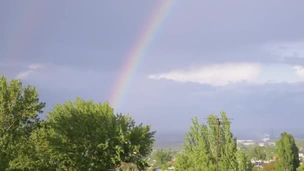 Aspecto de un arco iris brillante doble en el horizonte a través de nubes grises en el cielo. 4K — Vídeos de Stock