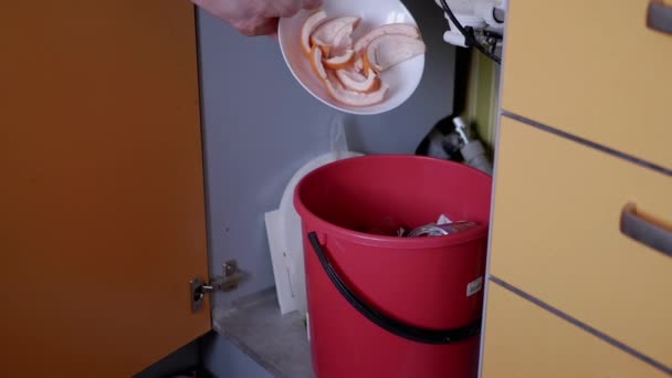 男性の手は、台所でゴミ箱にゴミ箱、オレンジピールをスローします。スローモーション. — ストック動画