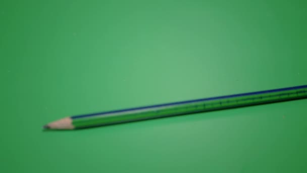 Simple Pencil for Drawing, Falls, Rolls over a Green Background. Slow motion — Stock Video