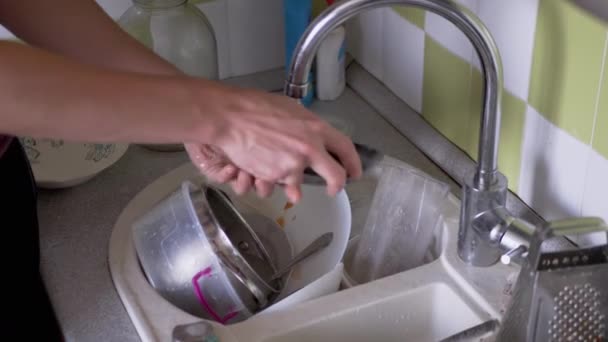 Mãos masculinas lava placa suja com uma esponja na pia da cozinha sob água corrente — Vídeo de Stock