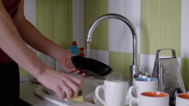 Mãos masculinas Lave a placa suja com uma esponja na pia da cozinha sob água corrente — Vídeo de Stock