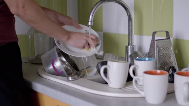 Man handen wassen vuile plaat met een spons in keuken gootsteen onder stromend water — Stockvideo