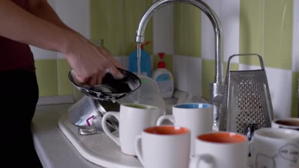 Man handen wassen vuile plaat met een spons in keuken gootsteen onder stromend water — Stockvideo