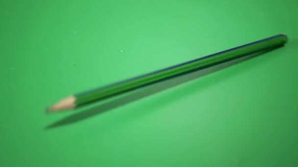 Simple Pencil for Drawing, Falls, Rolls over a Green Background. Slow motion — Stock Video