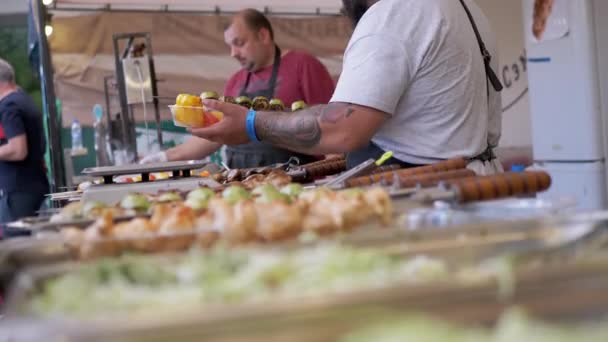 Торговец уличной едой готовит обед для клиента с овощами на гриле — стоковое видео