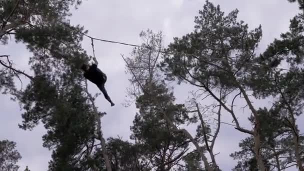 Corvo Ropewalker realizando acrobacias arriscadas em uma corda com seguro na floresta de pinheiro — Vídeo de Stock