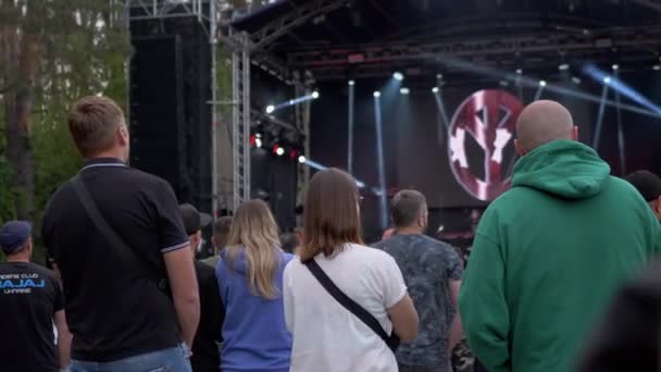 Samling av en folkmassa nära en öppen scen på en rockfestival. 4K — Stockvideo