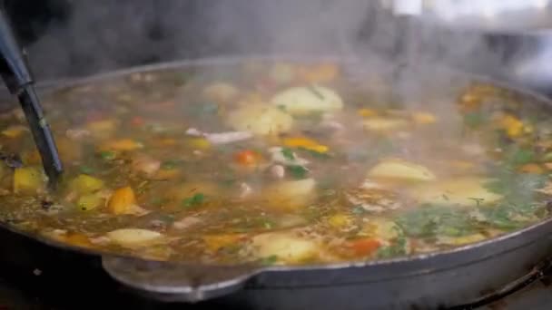 Chef callejero prepara un guiso de verduras al aire libre en una sartén de hierro fundido o Wok — Vídeos de Stock