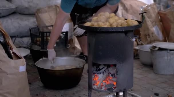Street Chef prepara batatas em um fogão a lenha com carvão brilhante. Zoom — Vídeo de Stock