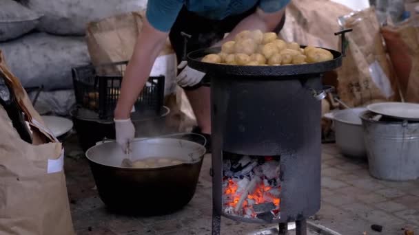 Street Chef bereidt aardappelen op een houtkachel met gloeiende kolen. Zoom — Stockvideo