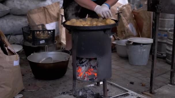 Street Chef prepara batatas em um fogão a lenha com carvão brilhante. Zoom — Vídeo de Stock