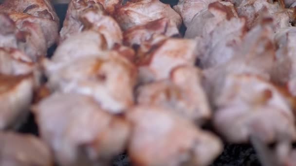 Cuisiner des kebabs juteux et croustillants avec de la fumée sur une brochette en métal sur le gril. Zoom — Video