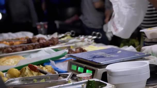 Vendedor ambulante pesa ensalada, kebabs, papas en una lonchera a escala electrónica — Vídeos de Stock
