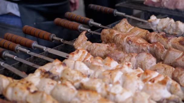 Приготовление сочной свиной кебаб на гриле на открытом воздухе на металлическом шампуре. 4K — стоковое видео