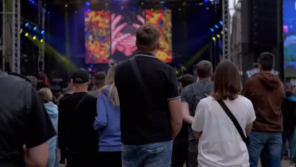 Собрание толпы людей у открытой сцены на рок-фестивале. 4K — стоковое видео