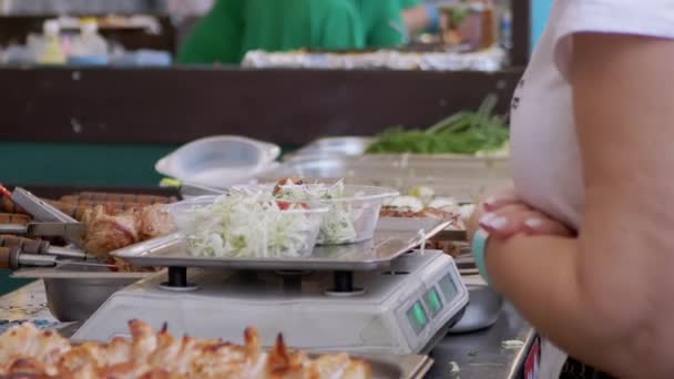 Straßenverkäufer wiegt Salate in einer Lunchbox auf elektronischer Waage. Zoom — Stockvideo