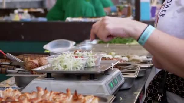 Vânzătorul Street Food cântărește o salată în cutii de prânz pe o scară electronică — Videoclip de stoc