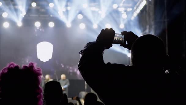 Männliche Aufnahme eines nächtlichen Rockkonzerts auf offener Bühne auf einem Smartphone. 4K — Stockvideo