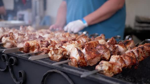 Chef cocinando un jugoso Kebab de cerdo en una parrilla abierta en un patio de comidas en una brocheta de metal — Vídeos de Stock