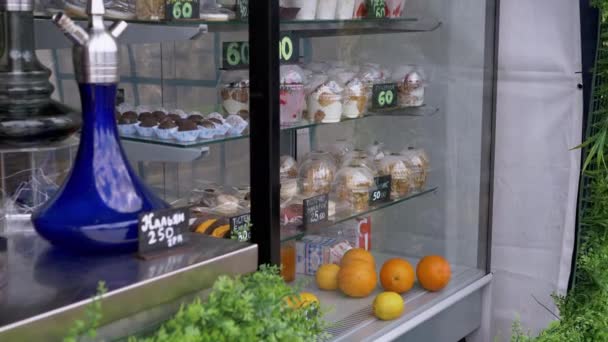 Postres dulces, pasteles, frutas se venden en el escaparate de cristal de la panadería. 4K — Vídeos de Stock