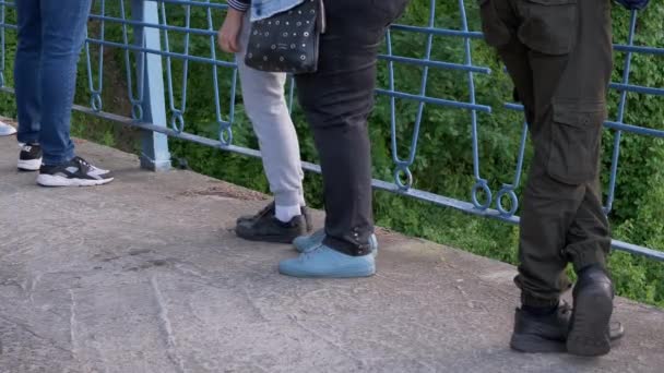 Crowd of Human Legs Stands at the Railing of a Concrete Bridge. 4K — Stockvideo