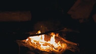 Çocuk, sigara yakan, yanan bir dalla oynuyor, Gece Ateşi 'ne yakın bir çubuk. 4K