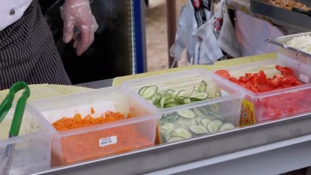 Уличный шеф-повар готовит вкусную шаурму из свежих овощей — стоковое видео