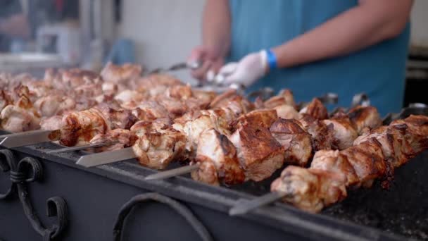 Chef cocinando un jugoso Kebab de cerdo en una parrilla abierta en un patio de comidas en una brocheta de metal — Vídeos de Stock