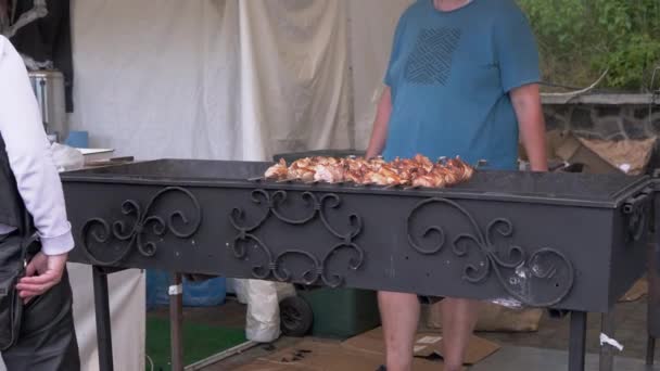 Vendedor ambulante vende barbacoa a la parrilla jugosa cocinada en el patio de comidas. 4K — Vídeo de stock