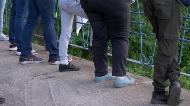 Crowd of Human Legs Stands at the Railing of a Concrete Bridge. 4K — Stock Video