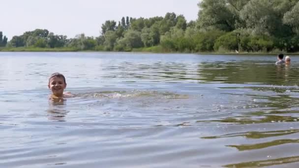 Gülümseyen Çocuk Suda, Nehirde, Dalgalar, Sıçramalar, Girdaplarda Yüzer. 4K — Stok video