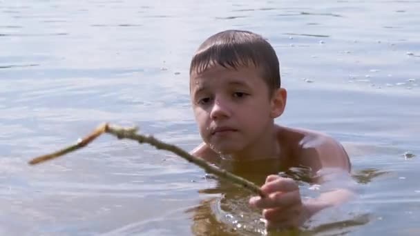 Aktif Çocuk Nehirde Bir Sopayla Oynuyor, Su Dalgaları Yaratıyor, Su Sıçratıyor — Stok video