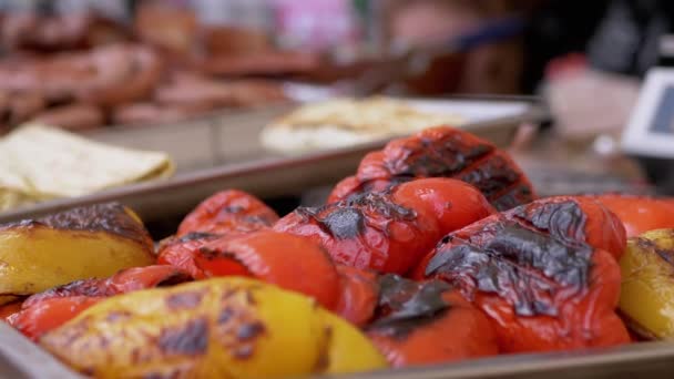 Grilované papriky s červenou kůrkou se prodávají v otevřené vitríně. Přiblížení — Stock video