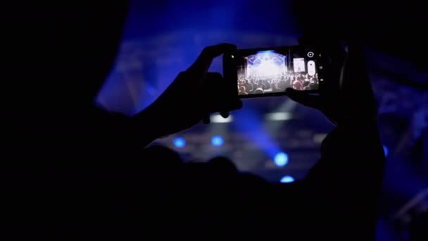 Male Record Video on a Smartphone of a Night Rock Concert on Open Stage (en inglés). 4K — Vídeo de stock