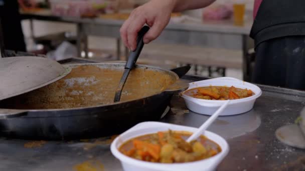 Street Chef bereidt een plantaardige stoofpot te koop in een gietijzeren ketel. 4K — Stockvideo