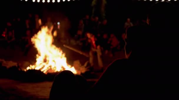 Cuplul iubitor stă și se uită la focul de noapte din pădure. 4K . — Videoclip de stoc