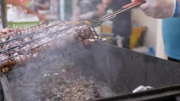 Уличный повар готовит сочные овощи на гриле, грибы на открытом воздухе в фуд-корте — стоковое видео